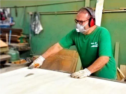 Marceneiro da equipe do Bilhar Brasa cortando a madeira da mesa